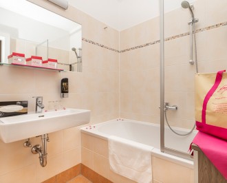 Badezimmer mit Duschwanne, Waschbecken und WC