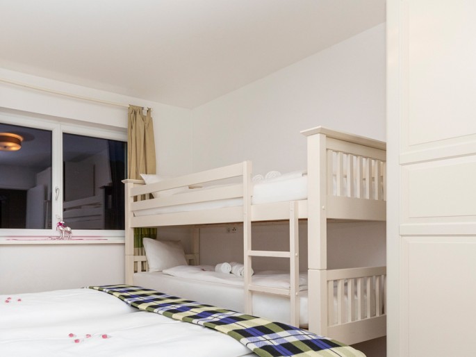 Schlafzimmer mit Doppelbett und Stockbett